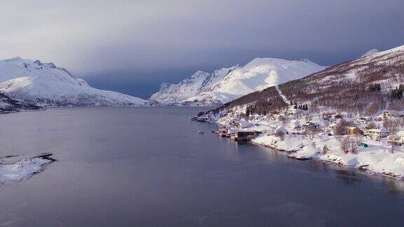 挪威冬季海岸线上白雪覆盖的山脉来自峡湾郡