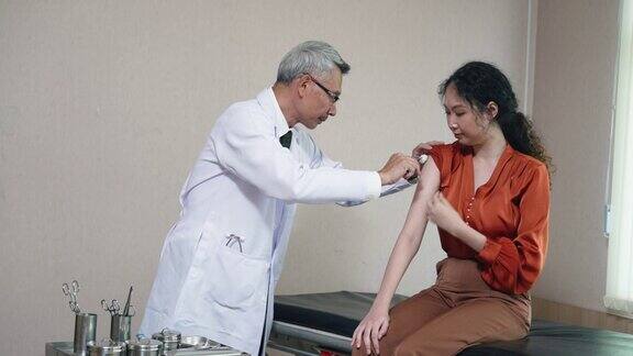 亚洲年轻女性去医生那里接种COVID-19疫苗