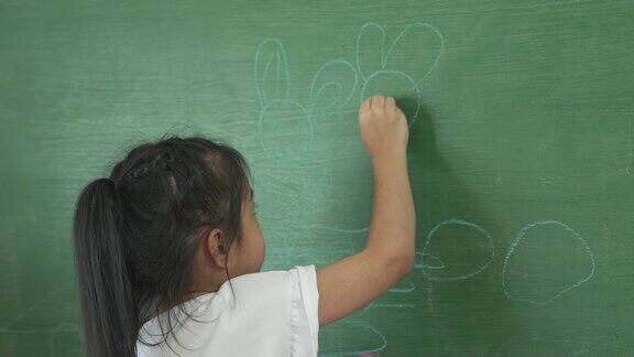小女孩在家里用黑板画画