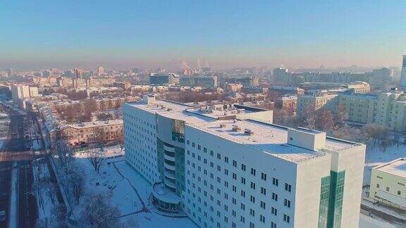 在晴朗寒冷的日子里鸟瞰被雪覆盖的冬季城市全景轨道摄影机运动