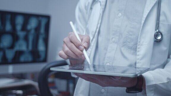 跟踪镜头:医生在数字平板电脑上检查病人的x光图像特写