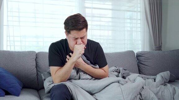 《年轻的亚洲男人》在家里沙发上患流感生病的4K视频片段