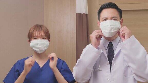 治疗冠状病毒感染患者后亚洲医生摘下防护口罩画像中的医护人员穿着病号服搓掉口罩心情舒畅笑容可掬