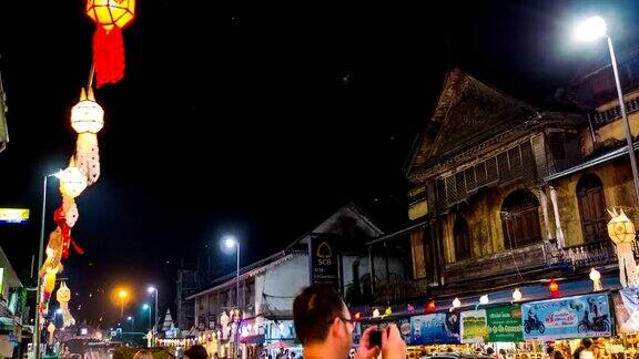 泰国彝蓬节上装饰着灯笼的风景道路上的夜间交通延时视频