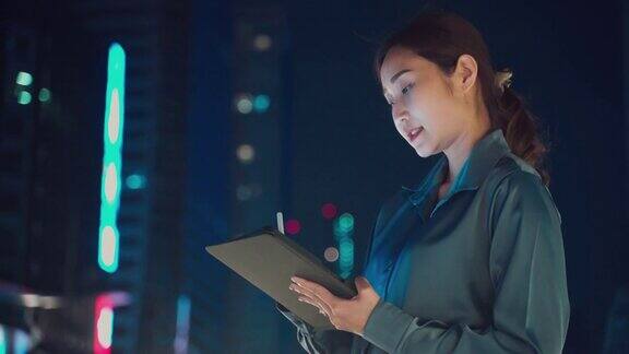 年轻的亚洲自由职业女商人晚上在办公室前用笔记本电脑