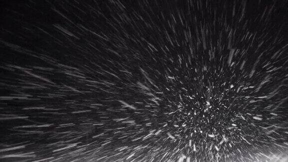 下雪大的和小的雪花冬天的暴风雪暴风雪汽车在一个晚上的雪道上行驶通过一个暴风雪
