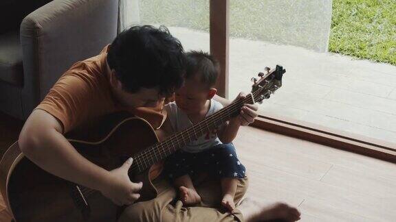 父亲和儿子在弹吉他孩子在学习使用乐器