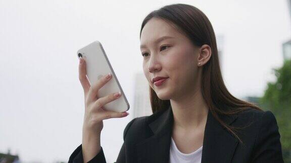 年轻的亚洲女商人使用手机与她的生意