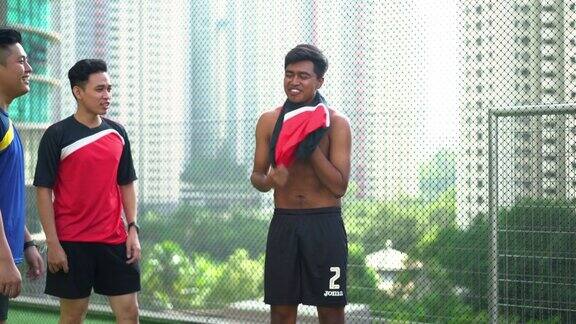 年轻的亚洲男子换上运动衫进行足球训练