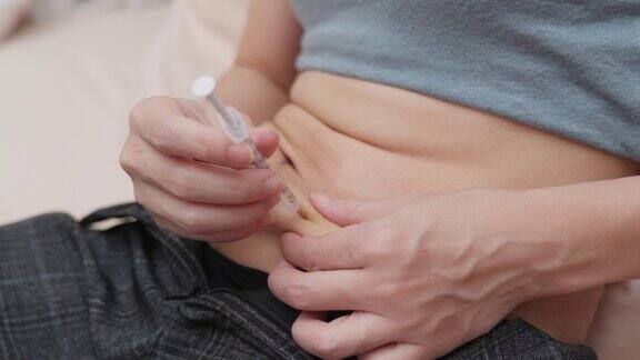 一名妇女在胃或腹部用注射器注射激素以增加卵巢刺激体外受精人体外受精治疗注射激素怀孕