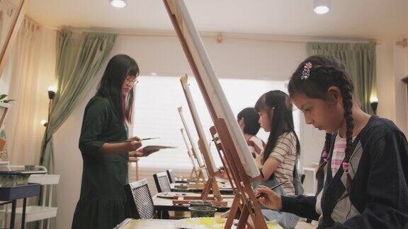 在美术工作室一群孩子在女老师的指导下学习丙烯酸颜料