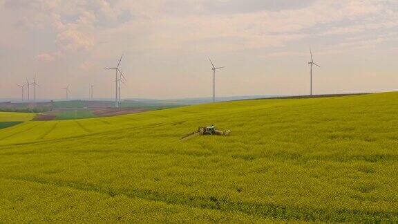 空中喷洒农药在油菜田周围的风力涡轮机