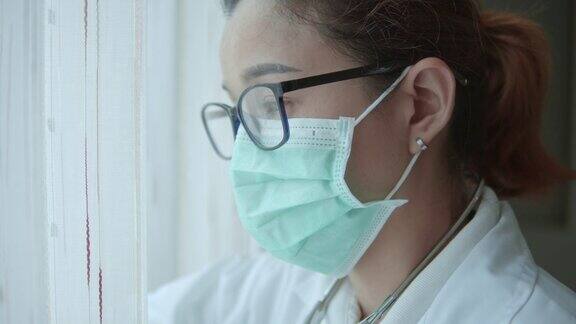 女医生戴着外科口罩看窗外特写