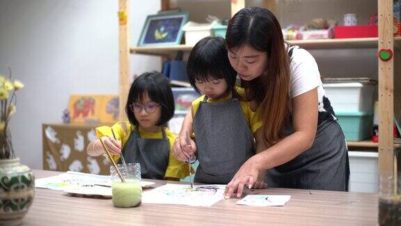 美术班老师在美术工作室教亚洲华人儿童绘画
