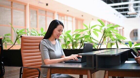 亚洲华人妇女在用笔记本电脑工作