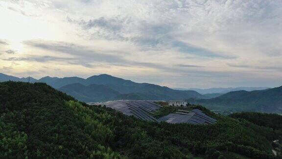 多云天气下山顶上壮观的太阳能发电站鸟瞰图