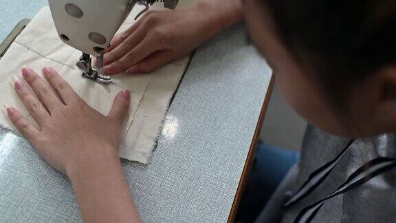 亚洲华裔女时装大学生在大学工作坊做服装缝纫项目