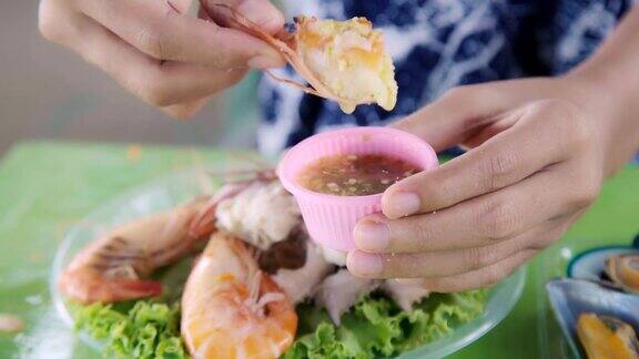 年轻的亚洲女人吃海鲜和木瓜沙拉泰国食物在海滩快乐的情绪