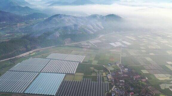 在晨雾中鸟瞰农场和山顶太阳能发电站