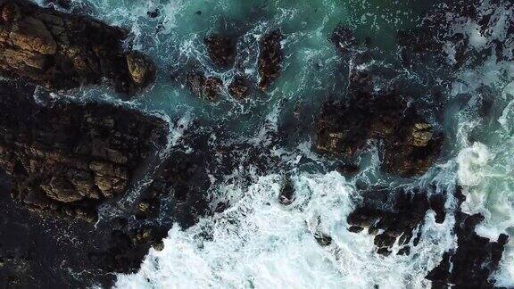 海浪撞击着黑色的岩石-鸟瞰图