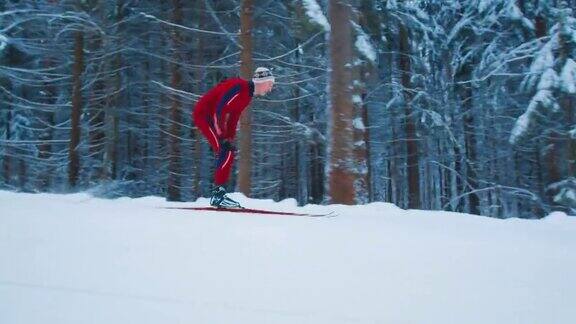 越野滑雪穿着红色滑雪服的年轻男子在冬季森林滑雪