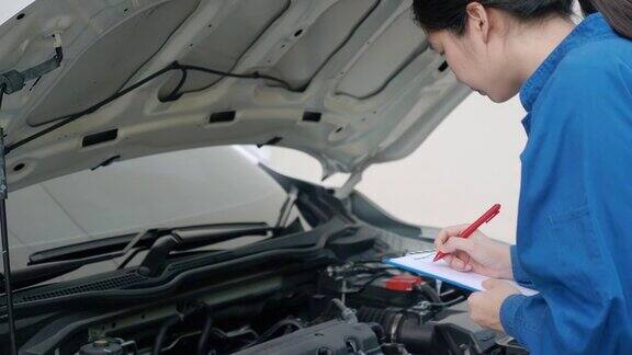 亚洲女机械师检查汽车