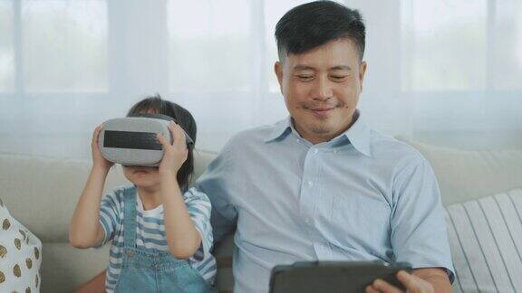 亚洲父亲教女儿使用VR虚拟现实眼镜