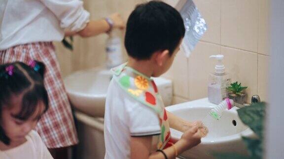 亚洲蒙特梭利学前班学生排队在水槽前洗手然后去吃早餐