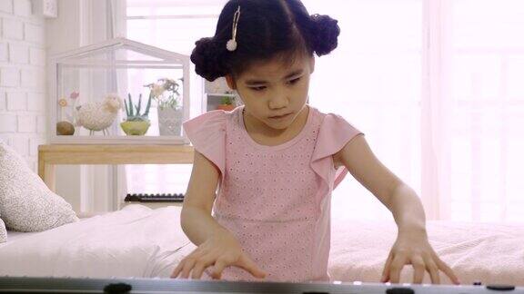 4K:亚洲小女孩正在接受电子钢琴训练是一种训练情感技巧和身体的活动在家或音乐学校学习音乐心理健康心情好
