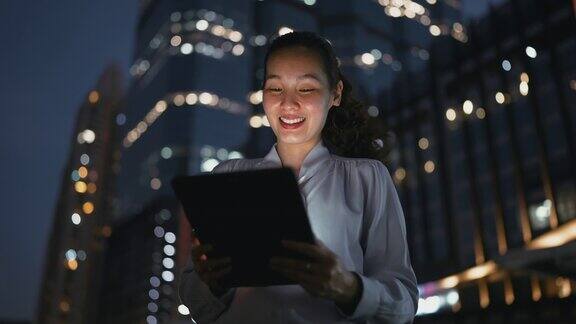 亚洲女商人在晚上使用数码平板电脑