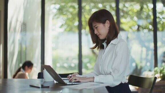 亚洲女商人使用笔记本电脑工作