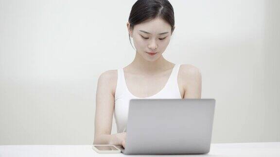 年轻的亚洲女性使用笔记本电脑在家工作