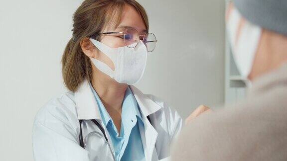 年轻的亚洲女医生戴着防护口罩在健康诊所为患有癌症的女性患者咨询医疗结果