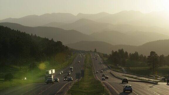 日落时分科罗拉多州落基山脉沿州际70号公路的东西向公路交通航拍