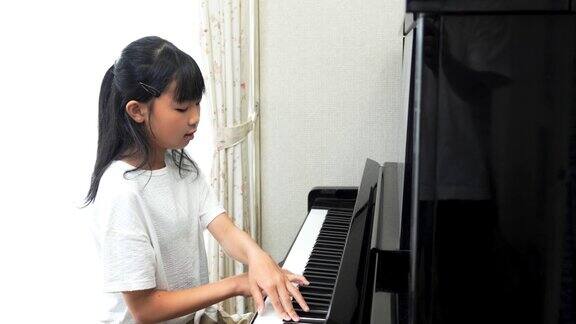 弹奏立式钢琴的日本女孩