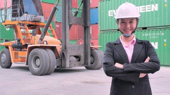 肖像亚洲女性工程师抱着双臂看着相机微笑着从货物货运交付商业增长联系商业赋权领导力妇女在STEM工业和运输集装箱