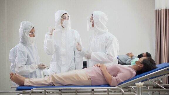 一群身穿防护服的医生正在医院隔离病房的病床上检查和治疗因感染冠状病毒的病人