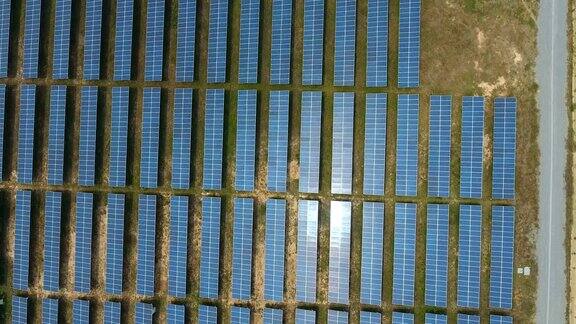 提供清洁可再生能源的一排排太阳能电池板发电厂的俯视图航拍视频