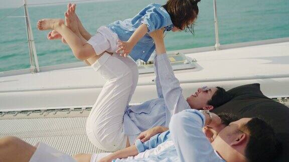 一个亚洲家庭带着两个孩子在游艇上玩得很开心