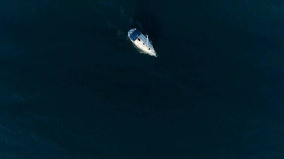 电影无人机鸟瞰显示在黑暗的海水孤独的单船