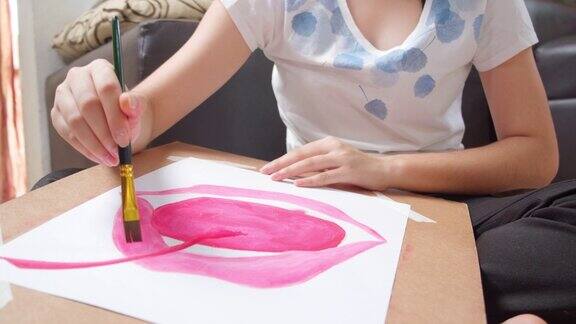 特写亚洲少女绘画和绘画她的艺术和工艺在客厅而呆在家里她用水彩和画笔在白纸上创作艺术项目形成自己的想象艺术和工艺概念