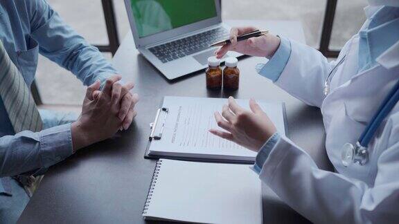 医生和病人在医院办公室体检时坐着聊天治疗师填写用药历史记录