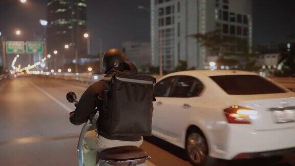 晚上在城市里骑摩托车的快递员
