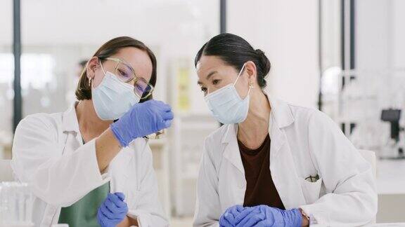 科学家、科学团队和戴口罩的亚洲妇女在清洁实验室进行液体化学或药物疫苗的医学研究团队合作为新冠肺炎的治愈和创新