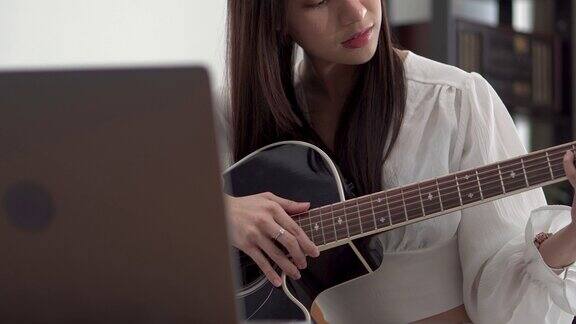 年轻女子在网上学习吉他课程
