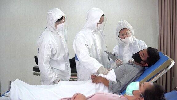 一群身穿防护服的亚洲医生正在医院隔离病房的病床上检查和治疗因冠状病毒或covid-19咳嗽的患者流感爆发