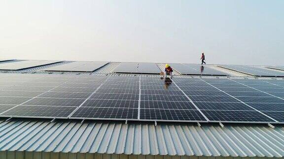 太阳能电池板技师用钻头在屋顶安装太阳能电池板的航拍照片
