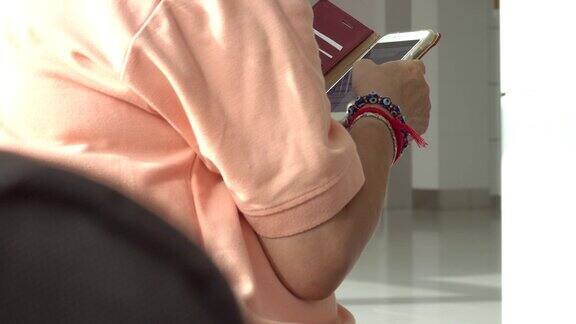 一女子在机场等待时使用智能手机