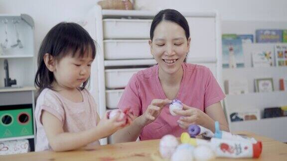 妈妈和他的女儿正在画鸡蛋