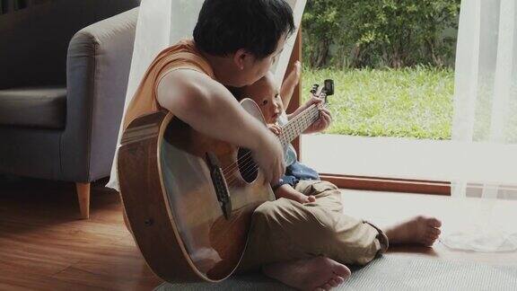 父亲和儿子在弹吉他孩子在学习使用乐器